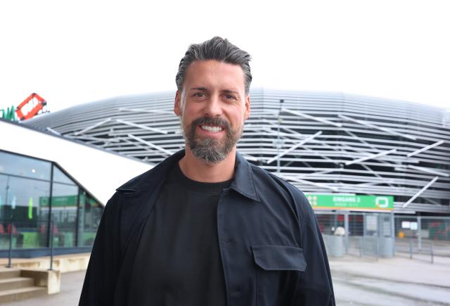 28 May 2025, Bavaria, Augsburg: Sandro Wagner, new coach of FC Augsburg, stands in front of the WWK Arena. Photo: Karl-Josef Hildenbrand/dpa - IMPORTANT NOTE: In accordance with the regulations of the DFL German Football League and the DFB German Football Association, it is prohibited to utilize or have utilized photographs taken in the stadium and/or of the match in the form of sequential images and/or video-like photo series.