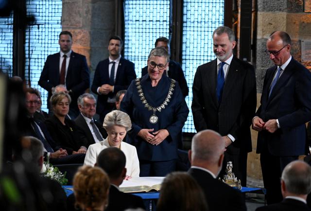 29 May 2025, North Rhine-Westphalia, Aachen: Ursula von der Leyen, President of the European Commission, signs the city's Golden Book after receiving the International Charlemagne Prize. Photo: Federico Gambarini/dpa-Pool/dpa