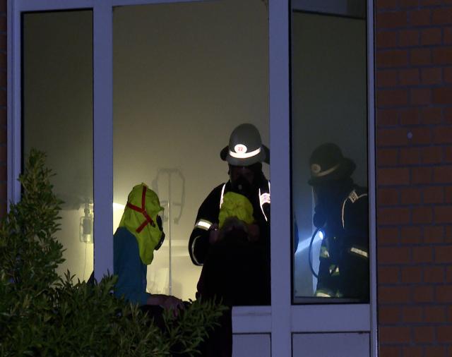 01 June 2025, Hamburg: Firefighters assist a patient inside a room during a fire at Marienkrankenhaus hospital in Hamburg's Hohenfelde district. The blaze left three patients dead and injured more than 50 others. Photo: Steven Hutchings/dpa