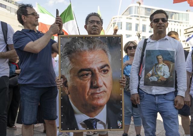 28 June 2025, Hesse, Frankfurt/Main: A man holds a photo of Reza Pahlavi II, who is living in exile, during a protest against the Mullah regime in Iran at the Hauptwache in Frankfurt. Photo: Boris Roessler/dpa