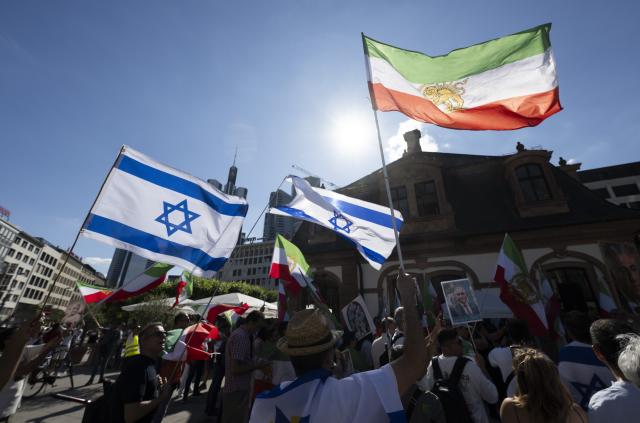 28 June 2025, Hesse, Frankfurt/Main: Mainly exiles and German-Iranians protest against the Mullah regime in Iran at a rally at the Hauptwache in Frankfurt. In addition to Israeli flags, the "Shah flag" of Iran is also waved. Photo: Boris Roessler/dpa