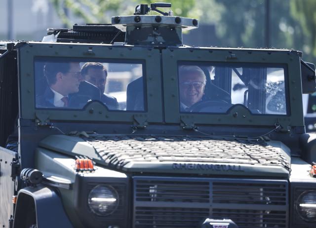 01 July 2025, North Rhine-Westphalia, Weeze: Armin Papperger (R), CEO of the Rheinmetall armaments group, and Hendrik Wüst (L), Minister President of North Rhine-Westphalia, drive around the Rheinmetall Aviation Service GmbH plant in Weeze in a military vehicle during the Minister President's visit. Rheinmetall is building a factory for military aircraft construction on an area of around 60,000 square meters. Fuselage center sections for the F-35 fighter jet are to be manufactured there from summer 2025. Photo: Oliver Berg/dpa