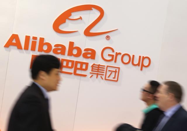 FILED - 16 March 2015, Lower Saxony, Hannover: People pass by the logo of the Chinese E-commerce Group Alibaba during the opening of CeBIT in Hannover. Photo: Christian Charisius/dpa