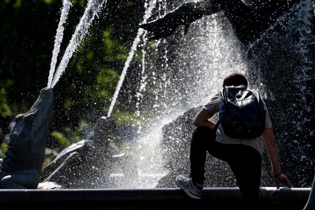 02 July 2025, Berlin: A person cools off at the Neptune Fountain in Berlin-Mitte. Photo: Fabian Sommer/dpa