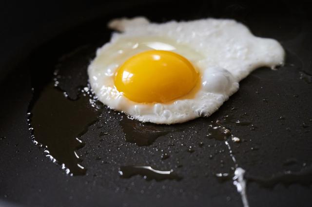 FILED - 30 March 2022, Berlin: An egg sizzles in frying oil in a pan. A teacher in southern France fried an egg on the scorching hot school playground floor, it was reported on Wednesday. Photo: Annette Riedl/dpa