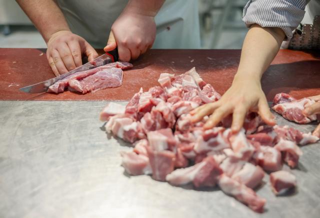 FILED - 12 February 2025, Saxony, Leipzig: A young butcher cuts pork. The series of serious cases of diarrhoea in northern France, with 29 children affected and one death, was caused by bacterially contaminated meat, officials said on Wednesday. Photo: Jan Woitas/dpa