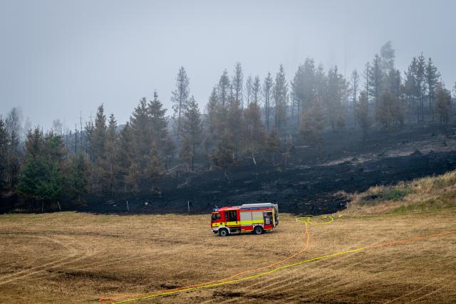 03 July 2025, Thuringia, Reichmannsdorf: Emergency services stand at the edge of the forest fire on the Saalfelder Höhe in Thuringia. The forest fire in the district of Saalfeld-Rudolstadt has triggered a disaster alert. The fire-fighting work is now continuing. Photo: Jacob Schröter/dpa