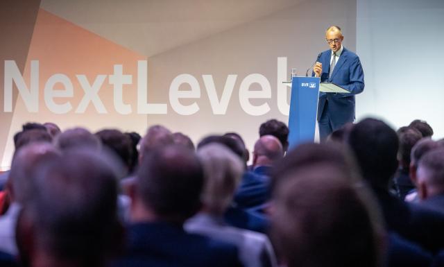 03 July 2025, Berlin: German Chancellor Friedrich Merz (back-R) speaks at the Banking Conference of the Federal Association of Volksbanken and Raiffeisenbanken. Photo: Michael Kappeler/dpa