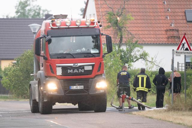 03 July 2025, Saxony, Neudorf: A tanker truck stands at a hydrant to draw water for extinguishing. A disaster alert has been issued for three municipalities in eastern Germany due to a forest fire. Photo: Sebastian Kahnert/dpa