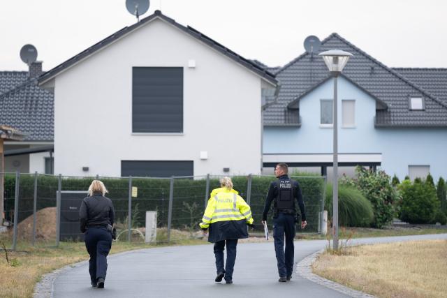 03 July 2025, Saxony, Neudorf: Police officers go from house to house to inform residents during an evacuation. A disaster alert has been issued for three communities in eastern Germany due to a forest fire. Photo: Sebastian Kahnert/dpa