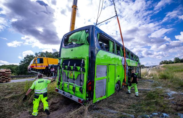 04 July 2025, Mecklenburg-Western Pomerania, Roebel: Rescue workers lift the Flixbus at the scene of the accident on Highway 19 in the Mecklenburgische Seenplatte district, where the bus left the road and overturned, injuring numerous passengers. Photo: Jens Büttner/dpa