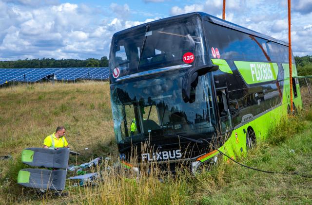 04 July 2025, Mecklenburg-Western Pomerania, Roebel: Rescue workers clear the scene after a Flixbus veered off the road and overturned in a serious accident on Highway 19 in the Mecklenburgische Seenplatte district overnight, leaving numerous people injured. Photo: Jens Büttner/dpa