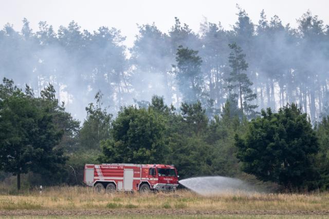 04 July 2025, Saxony, Nieska: Fire engines of the fire department put out the fire that erupted in the Gohrischheide in the district of Meissen. Firefighters are battling forest fires in several places in eastern Germany. Photo: Sebastian Kahnert/dpa
