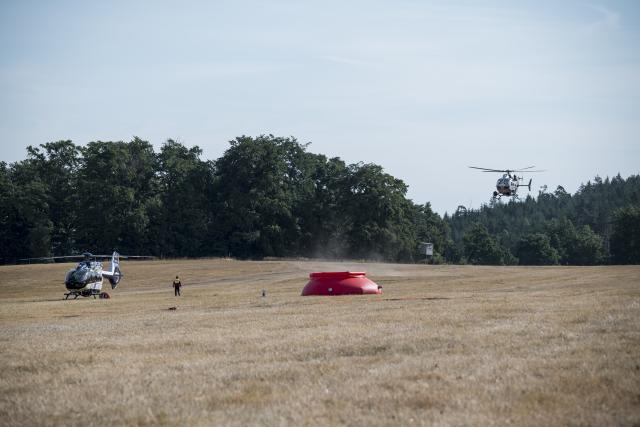 05 July 2025, Thuringia, Reichmannsdorf: Two fire-fighting helicopters are ready for their mission at the forest fire on the Saalfelder Höhe. Photo: Daniel Vogl/dpa
