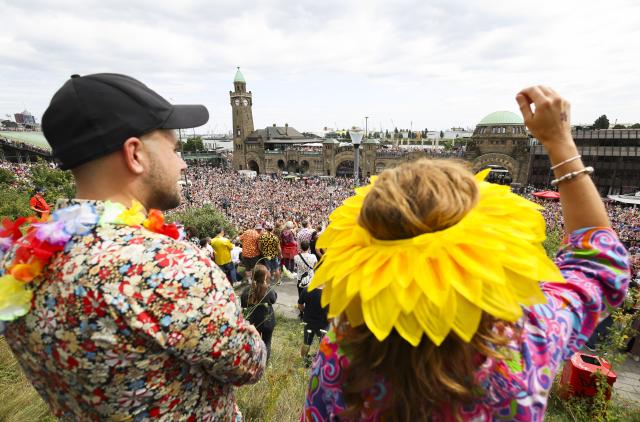 05 July 2025, Hamburg: Participants of the 27th Schlagermove follow the Schlager caravan through the St. Pauli district. The Schlagermove is a large, annual street parade and festival in Hamburg, Germany, celebrating Schlager music, a genre of German pop music. Photo: Christian Charisius/dpa