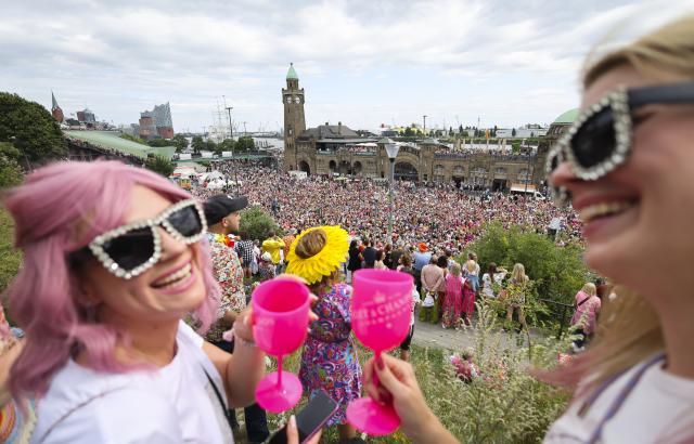05 July 2025, Hamburg: Participants of the 27th Schlagermove follow the Schlager caravan through the St. Pauli district. The Schlagermove is a large, annual street parade and festival in Hamburg, Germany, celebrating Schlager music, a genre of German pop music. Photo: Christian Charisius/dpa