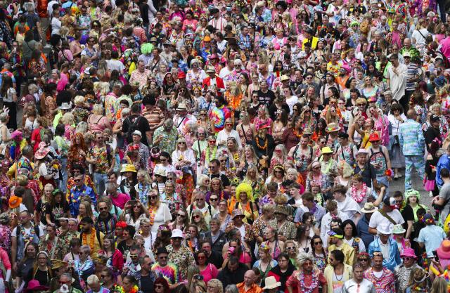 05 July 2025, Hamburg: Participants of the 27th Schlagermove follow the Schlager caravan through the St. Pauli district. The Schlagermove is a large, annual street parade and festival in Hamburg, Germany, celebrating Schlager music, a genre of German pop music. Photo: Christian Charisius/dpa