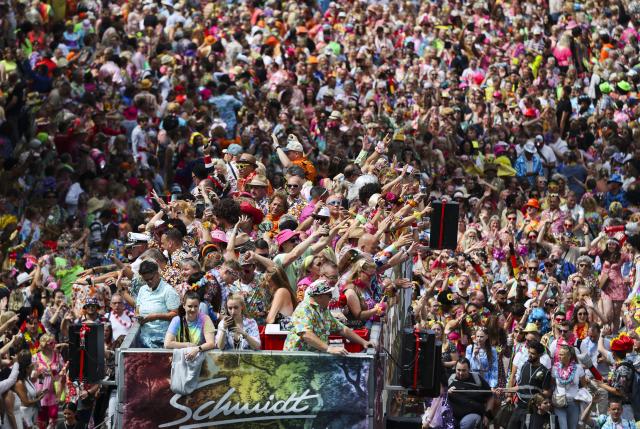 05 July 2025, Hamburg: Participants of the 27th Schlagermove follow the Schlager caravan through the St. Pauli district. The Schlagermove is a large, annual street parade and festival in Hamburg, Germany, celebrating Schlager music, a genre of German pop music. Photo: Christian Charisius/dpa