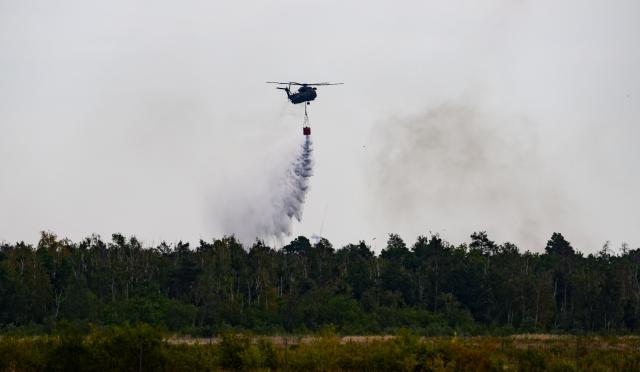 06 July 2025, Saxony, Jacobsthal: A Bundeswehr fire-fighting helicopter flies to the forest fire in Gohrischheide. The forest area between Saxony and Brandenburg has been burning for several days. Photo: Robert Michael/dpa