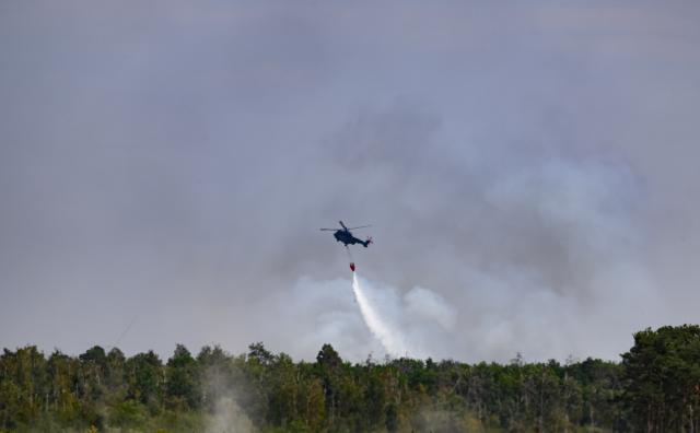 06 July 2025, Saxony, Jacobsthal: A federal police fire-fighting helicopter is deployed in the Gohrischheide forest fire. The forest area between Saxony and Brandenburg has been burning for several days. Photo: Robert Michael/dpa