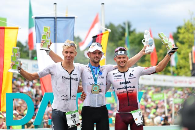 06 July 2025, Bavaria, Roth: (L-R) Second-placed German triathlete Jonas Schomburg, the winner French triathlete Sam Laidlow and third-placed German triathlete Jan Stratmann celebrate at the award ceremony after the Triathlon Challenge Ironman (3.86 km swim, 180 km bike, 42.195 km run). Photo: Daniel Karmann/dpa
