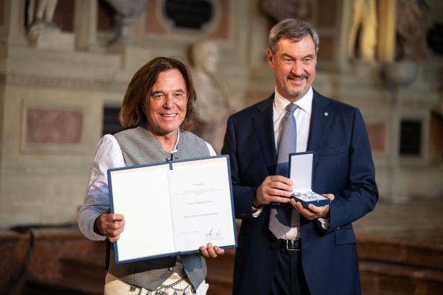 09 July 2025, Bavaria, Munich: Markus Soeder (R), Minister President of Bavaria, awards the Bavarian Order of Merit to German singer Juergen Drews. Photo: Lukas Barth/dpa