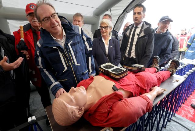 12 July 2025, Mecklenburg-Western Pomerania, Rostock: Alexander Dobrindt, German Minister of the Interior, has the care of injured people demonstrated to him during a tour of the nationwide Civil Protection Day in the Hanseatic city's harbor. Photo: Bernd Wüstneck/dpa