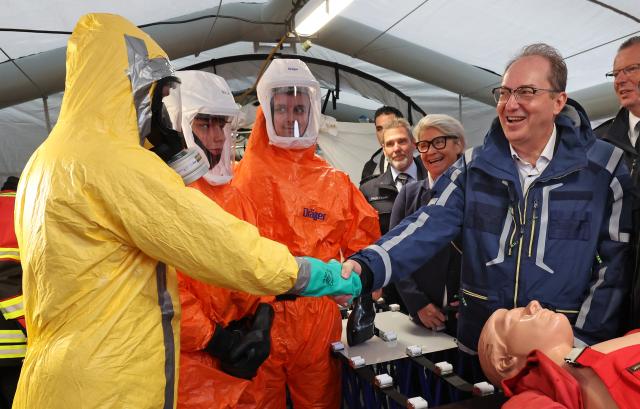 12 July 2025, Mecklenburg-Western Pomerania, Rostock: Alexander Dobrindt, German Minister of the Interior, learns about firefighter operations involving hazardous substances at the nationwide Civil Protection Day in the Hanseatic city's city harbor. Photo: Bernd Wüstneck/dpa