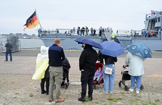 12 July 2025, Lower Saxony, Wilhelmshaven: A few guests stand in front of the frigate in the rain. The frigate "Hamburg" is to join NATO's maritime task force SNMG1, consisting of several destroyers and frigates and other ships from various NATO member states. This NATO maritime task force has been in existence since 1967. Before SNMG1 was given its current name in 2005, it was called "Standing Naval Force Atlantic". Photo: Lars Penning/dpa