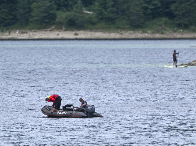 FILED - 07 July 2025, Bavaria, Grainau: Police divers with an inflatable boat search for two missing people on Lake Eibsee. According to the police, a 33-year-old man and his six-year-old son went under in the lake. They were on a pedal boat. Photo: Peter Kneffel/dpa