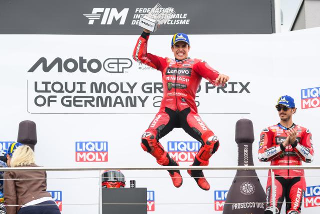 13 July 2025, Saxony, Hohenstein-Ernstthal: Spanish motorcycle racer Marc Marquez (C) of the Ducati Lenovo Team celebrates on the podium after winning the MotoGP race at the German Grand Prix at Sachsenring, alongside third-placed Italian rider Francesco "Pecco" Bagnaia (R), also of the Ducati Lenovo Team. Photo: Robert Michael/dpa