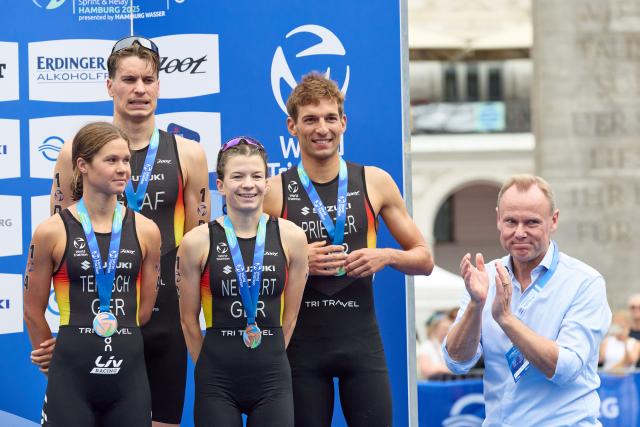 13 July 2025, Hamburg: Andy Grote (R), Hamburg's Senator for the Interior and Sports, applauds the German team during the ITU World Triathlon Series/World Championship mixed event. Photo: Georg Wendt/dpa