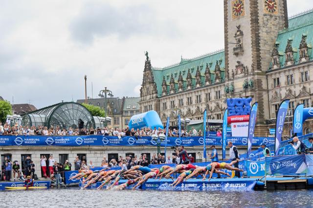 13 July 2025, Hamburg: The women's race gets underway as athletes jump into the Kleine Alster during the ITU World Triathlon Series/World Championship mixed event. Photo: Georg Wendt/dpa