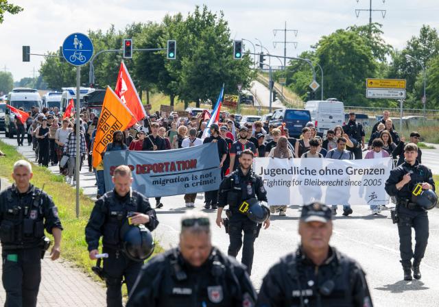 13 July 2025, Brandenburg, Schoenefeld: Participants in a demonstration against the planned deportation center at BER Airport carry a banner reading "Young People Without Borders. Fighting for the Right to Stay Since 2005." Photo: Soeren Stache/dpa
