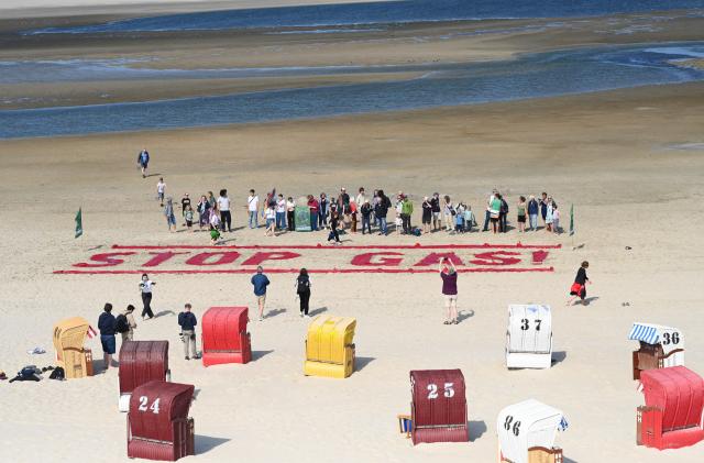 15 July 2025, Lower Saxony, Borkum: An aerial view taken with a drone shows "STOP GAS" written in red letters in the sand on Borkum beach. Activists from "Fridays for Future" demonstrate on Borkum against gas drilling off Borkum. Photo: Lars Penning/dpa