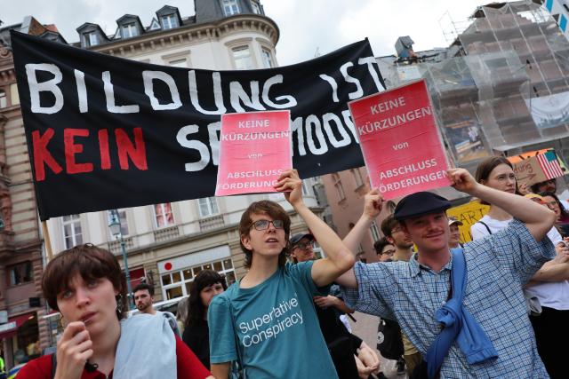 15 July 2025, Hesse, Wiesbaden: Participants in a rally against the black-red austerity plans for universities in Hesse stand on the Schloßplatz in front of the town hall. Photo: Jörg Halisch/dpa