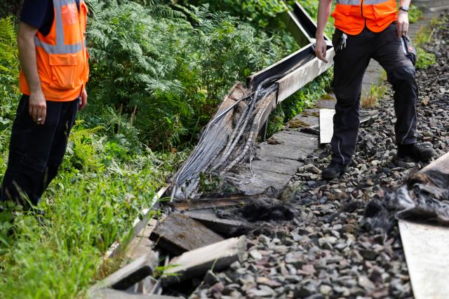 31 July 2025, North Rhine-Westphalia, Duesseldorf: Deutsche Bahn employees work on a section of track in Duesseldorf after a fire was set in a cable tunnel next to the railroad line, affecting six cables. Photo: Christoph Reichwein/dpa