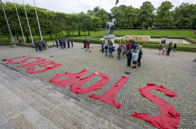 04 August 2025, Bavaria, Munich: Young people holding signs in front of the Bavarian State Chancellery take part in a Fridays for Future protest action against the planned drilling for natural gas in the Bavarian village of Reichling and have placed the words "Stop Gas!" made of red fabric on the ground in front of the grand staircase. Photo: Peter Kneffel/dpa