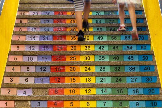 11 August 2025, Thuringia, Erfurt: First-year pupils at the "Am Schwemmbach" Cooperative Comprehensive School walk up a decorated staircase on their first day of school. Photo: Michael Reichel/dpa