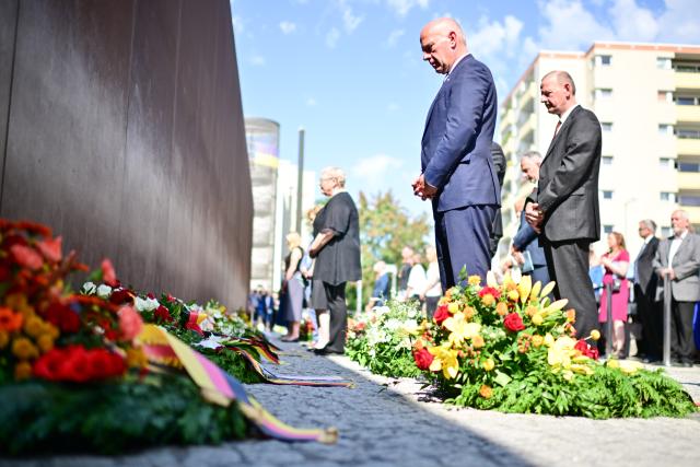 13 August 2025, Berlin: Kai Wegner (C), Governing Mayor of Berlin, lays a wreath at the Berlin Wall Memorial on the corner of Ackerstrasse and Bernauer Strasse. Photo: Sebastian Christoph Gollnow/dpa