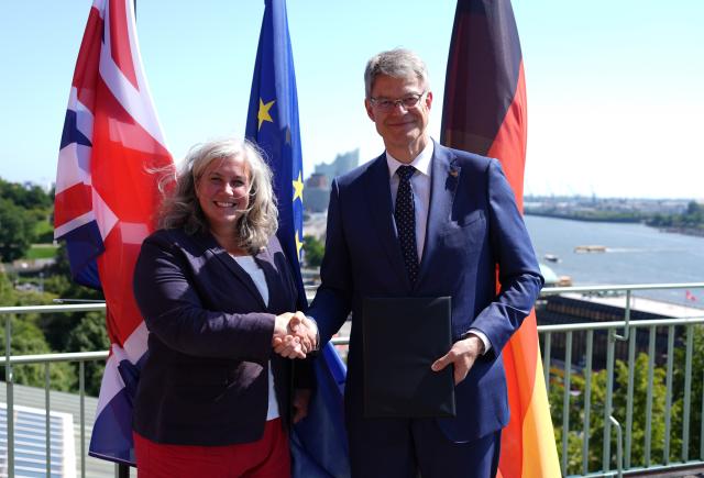 13 August 2025, Hamburg: German Minister for Transport Patrick Schnieder (R) and UK Transport Minister Heidi Alexander shake hands on the roof terrace of the Federal Maritime and Hydrographic Agency after signing a joint declaration of intent for a future direct cross-border long-distance passenger rail link between Germany and the United Kingdom. Photo: Marcus Brandt/dpa