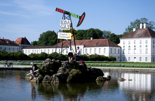 14 August 2025, Bavaria, Munich: Activists from Extinction Rebellion have erected a symbolic drilling rig in front of Nymphenburg Palace calling for an immediate halt to all new fossil fuel projects in Germany and a clear political commitment to climate protection. Photo: Sven Hoppe/dpa