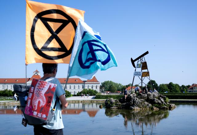 14 August 2025, Bavaria, Munich: Activists from Extinction Rebellion have erected a symbolic drilling rig in front of Nymphenburg Palace calling for an immediate halt to all new fossil fuel projects in Germany and a clear political commitment to climate protection. Photo: Sven Hoppe/dpa