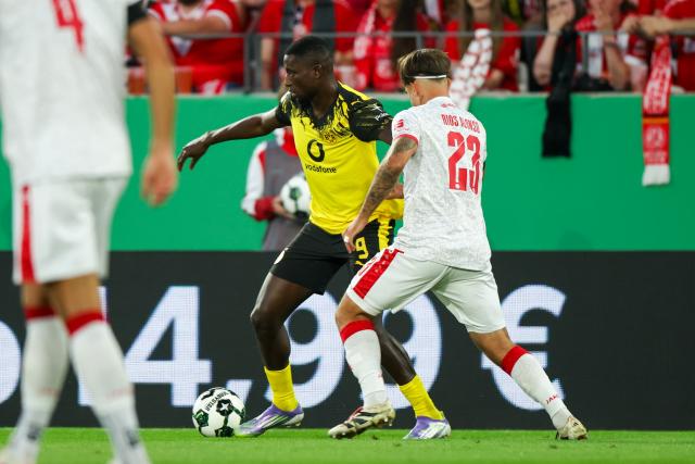 18 August 2025, North Rhine-Westphalia, Essen: Borussia Dortmund's Serhou Guirassy (L) and Essen's Jose-Enrique Rios Alonso battle for the ball during the German DFB Cup 1st round soccer match between Rot-Weiss Essen and Borussia Dortmund at Stadion an der Hafenstrasse. Photo: Christoph Reichwein/dpa - WICHTIGER HINWEIS: Gemäß den Vorgaben der DFL Deutsche Fußball Liga bzw. des DFB Deutscher Fußball-Bund ist es untersagt, in dem Stadion und/oder vom Spiel angefertigte Fotoaufnahmen in Form von Sequenzbildern und/oder videoähnlichen Fotostrecken zu verwerten bzw. verwerten zu lassen.