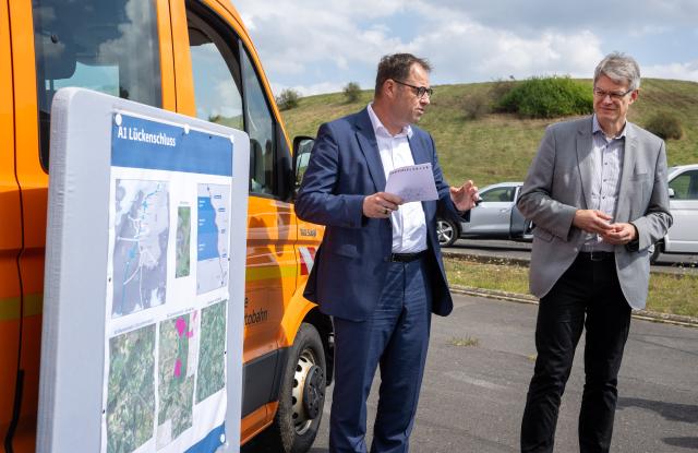 21 August 2025, Rhineland-Palatinate, Kelberg: German Transport Minister Patrick Schnieder (R) listens to the explanations of BMV Head of Road Construction Department Michael Puschel at the Kelberg junction of the A1 highway. Photo: Harald Tittel/dpa