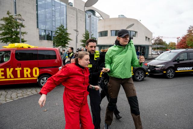 09 October 2025, Berlin: Greenpeace activists are taken away by the police in front of the Chancellery. Photo: Fabian Sommer/dpa