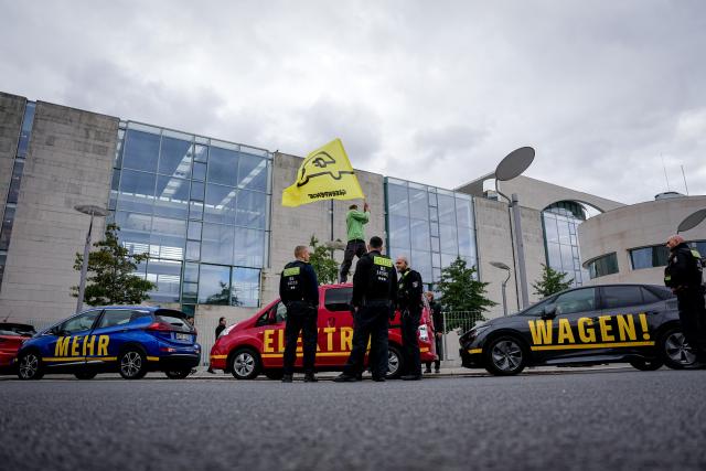 09 October 2025, Berlin: Greenpeace activists use electric vehicles to block an access road to the German Chancellery, where the "Car Summit" has been taking place with the German Chancellor since midday. Photo: Kay Nietfeld/dpa