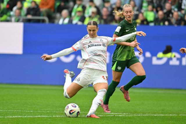 11 October 2025, Lower Saxony, Wolfsburg: Bayern Munich's Klara Buehl (L) shoots at goal during the German Bundesliga Women soccer match between VfL Wolfsburg and Bayern Munich at Volkswagen Arena. Photo: Swen Pförtner/dpa - IMPORTANT NOTICE: DFL and DFB regulations prohibit any use of photographs as image sequences and/or quasi-video.
