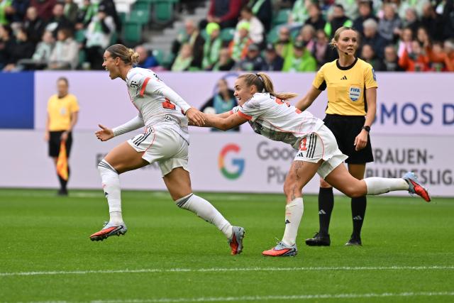 11 October 2025, Lower Saxony, Wolfsburg: Bayern Munich's Klara Buehl (L) celebrates with her teammate Georgia Stanway after scoring her side's first goal of the game during the German Bundesliga Women soccer match between VfL Wolfsburg and Bayern Munich at Volkswagen Arena. Photo: Swen Pförtner/dpa - IMPORTANT NOTICE: DFL and DFB regulations prohibit any use of photographs as image sequences and/or quasi-video.