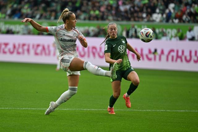 11 October 2025, Lower Saxony, Wolfsburg: Bayern Munich's Giulia Gwinn (L) and Wolfsburg's Janou Levels battle for the ball during the German Bundesliga Women soccer match betweeb VfL Wolfsburg and Bayern Munich at Volkswagen Arena. Photo: Swen Pförtner/dpa - IMPORTANT NOTICE: DFL and DFB regulations prohibit any use of photographs as image sequences and/or quasi-video.